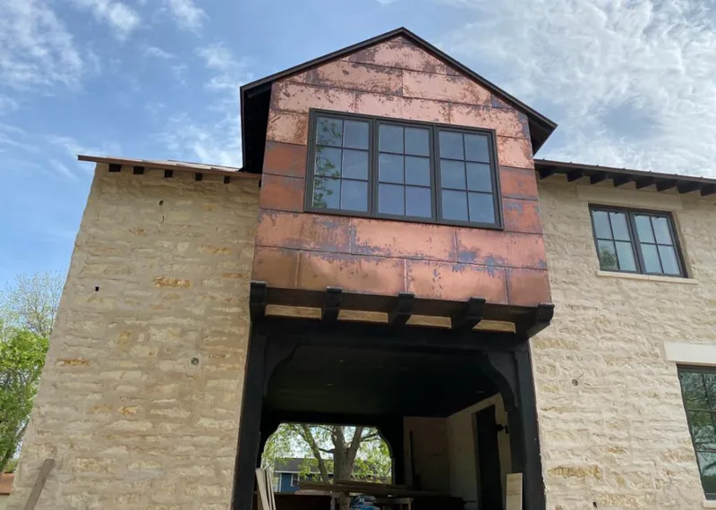 Copper metal panel facade on a stone building for Roof Repair in Stanton