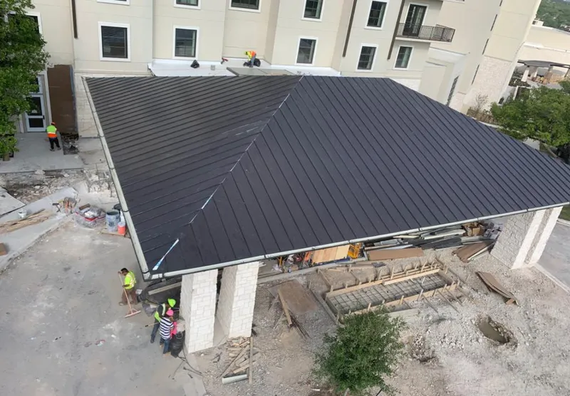 Metal roofing installation team working on a commercial building in Stanton